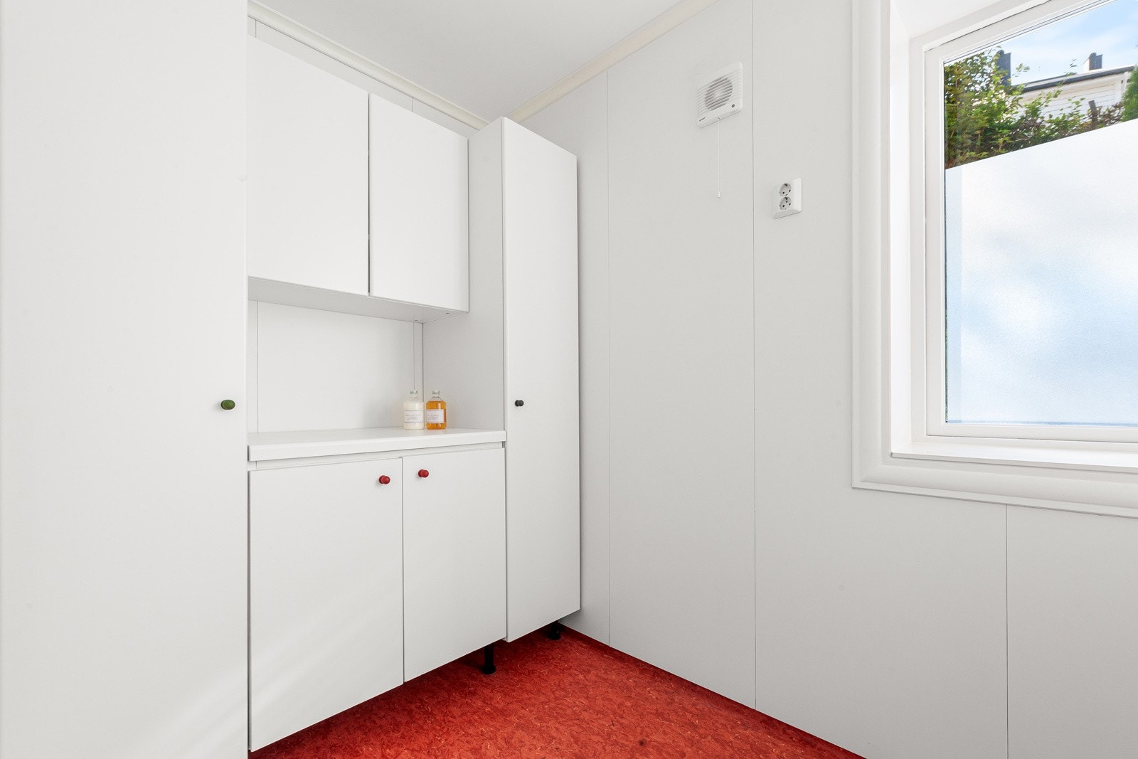 Leilighetens vaskerom med skap, hyller og benkeplass. Her er det god plass til vaskemaskin og tørketrommel. Det er også utslagsvask. Galleribilde