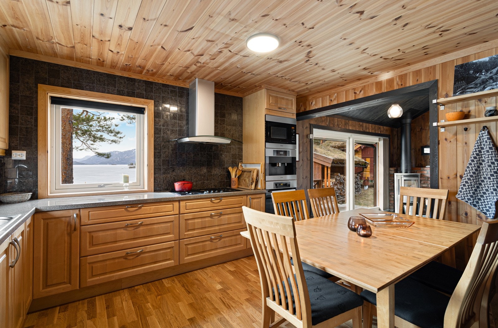 Kjøkkenet har godt med skap- og benkeplass, integrerte hvitevarer og et hyggelig spiseområde. Galleribilde