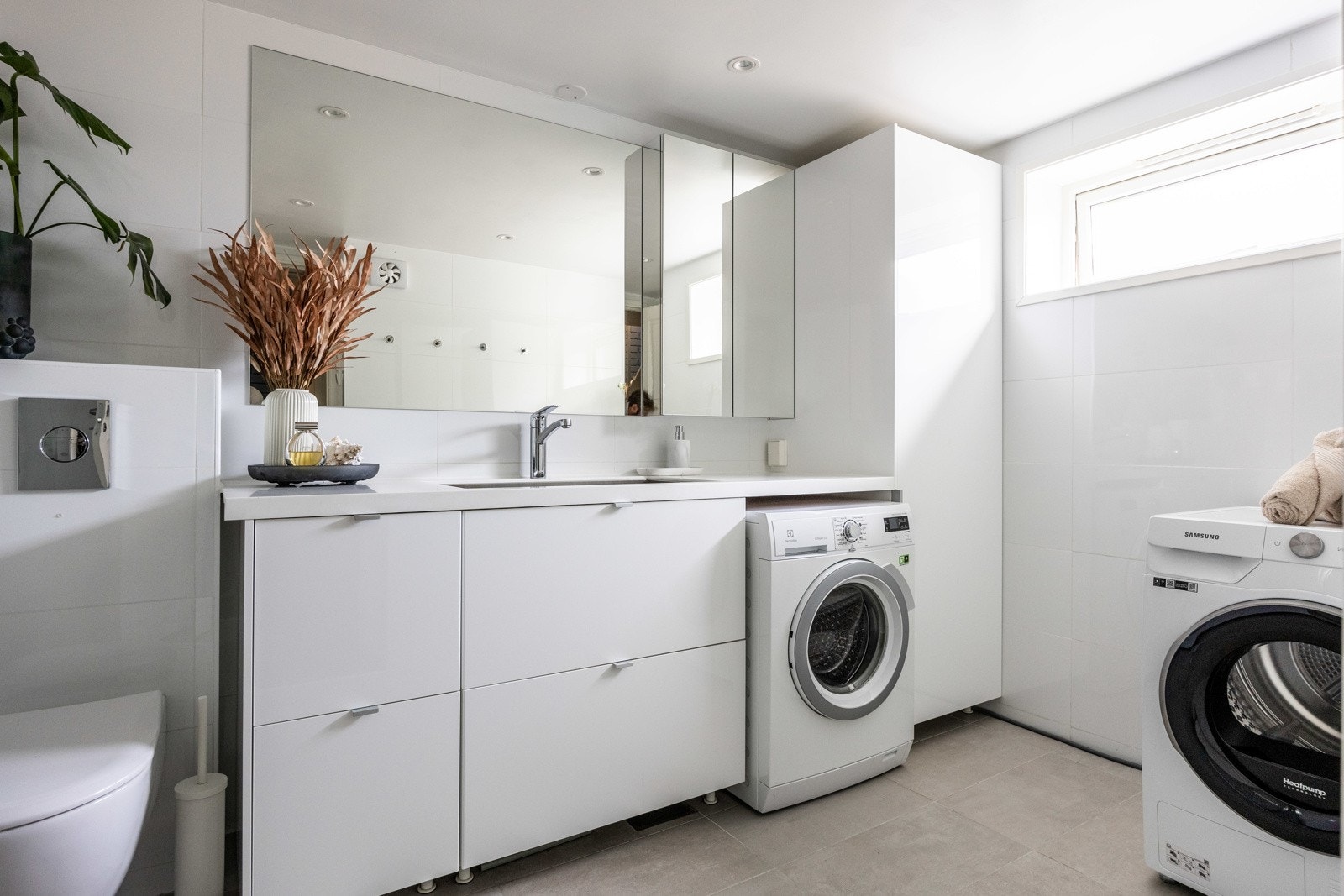 Helfliset baderom fra 2017 med slett innredning og benk i kompositt med innfelt stålvask. Galleribilde