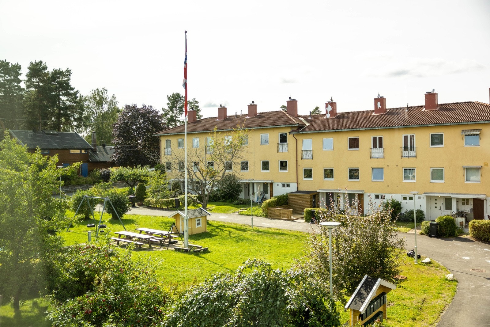 Utsyn mot fellesarealet og lekeplassen fra terrassen. Galleribilde
