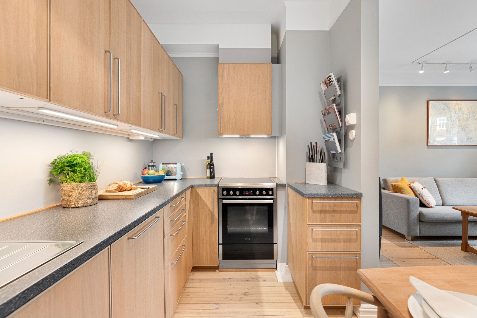 Mørk benkeplate med nedfelt stålkum og ett-greps armatur i krom Galleribilde