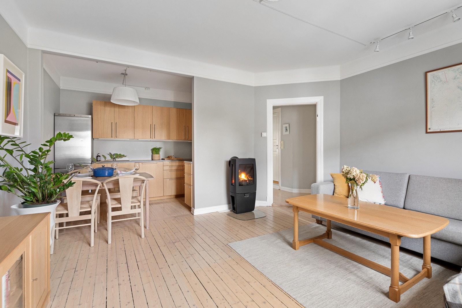 Store vindusflater kombinert med peisovn og lyse farger gir en luftig, lys og lun atmosfære Galleribilde