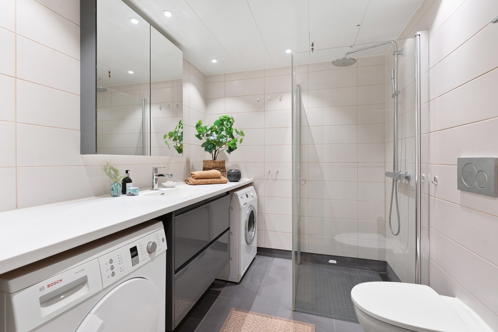 Stilrent og flislagt baderom med gulvvarme og downlights i takhimling Galleribilde