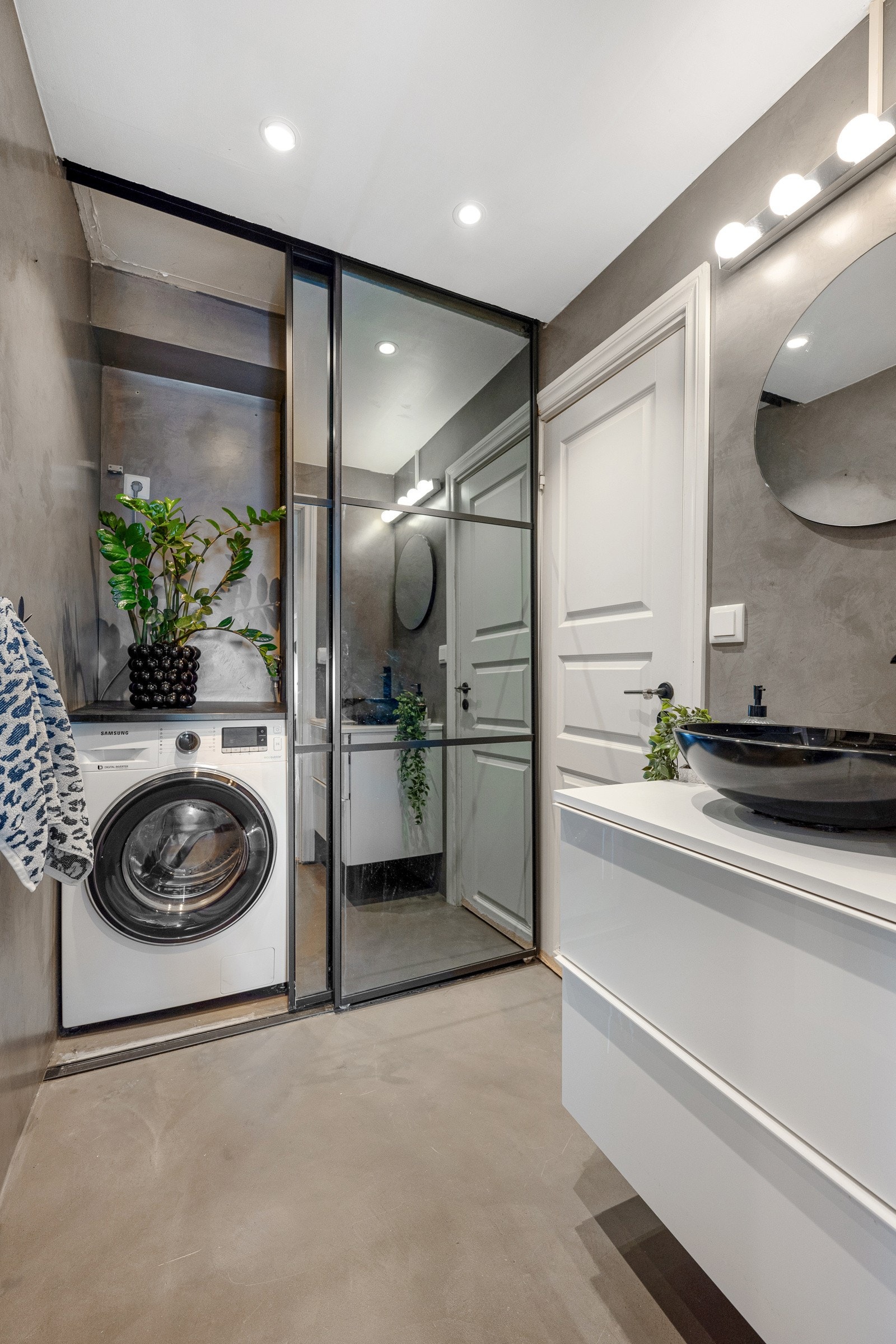 Badet er delt i tre avdelinger. Dette er den første som inneholder servant og vaskemaskin/tørketrommel i en skyvedørsgarderobe. Galleribilde