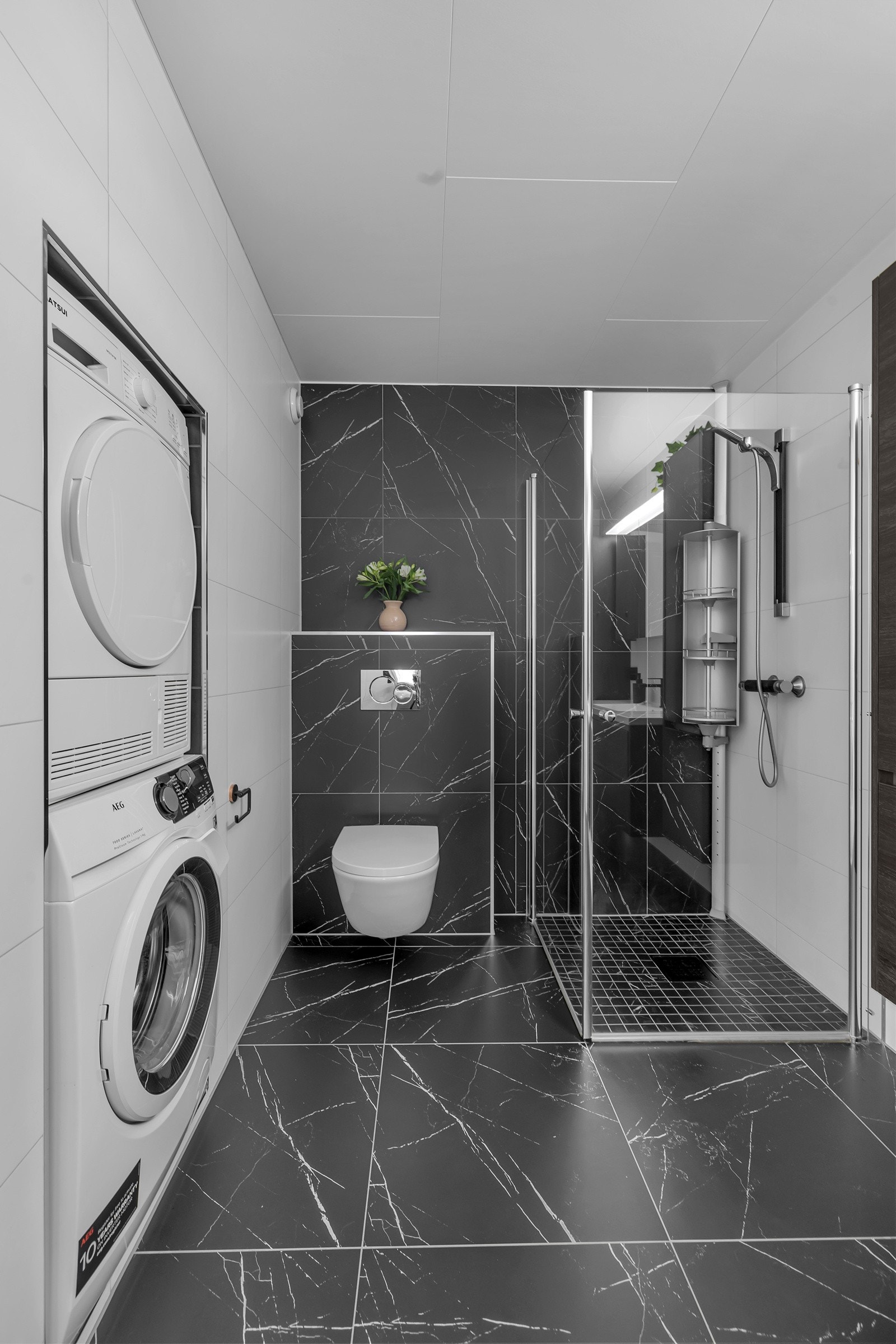 Flislagt gulv med varme, flislagte vegger, dusjhjørne med dører, praktisk innredning med lagring i kolomialskuffer m.m. Galleribilde