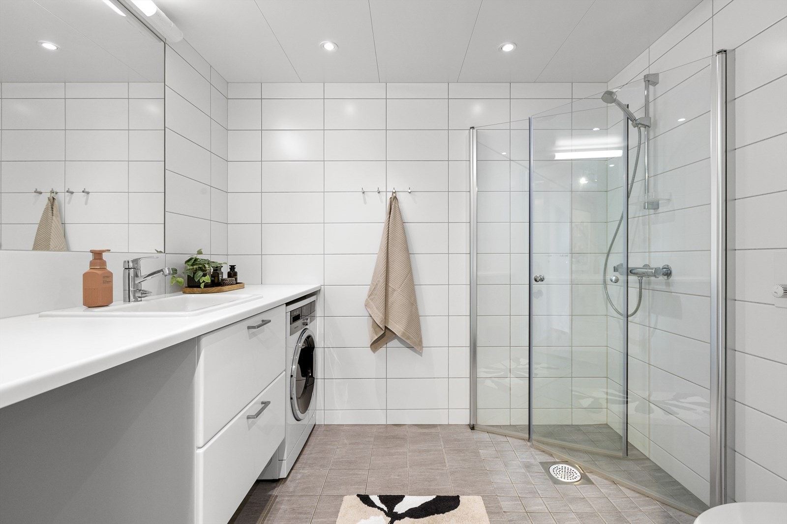 Delikat flislagt bad med varme i gulv og downlights i himling. Prefabrikkert våtromsmodul (badekabin). Aktuell byggeforskrift er teknisk forskrift 2017. Galleribilde