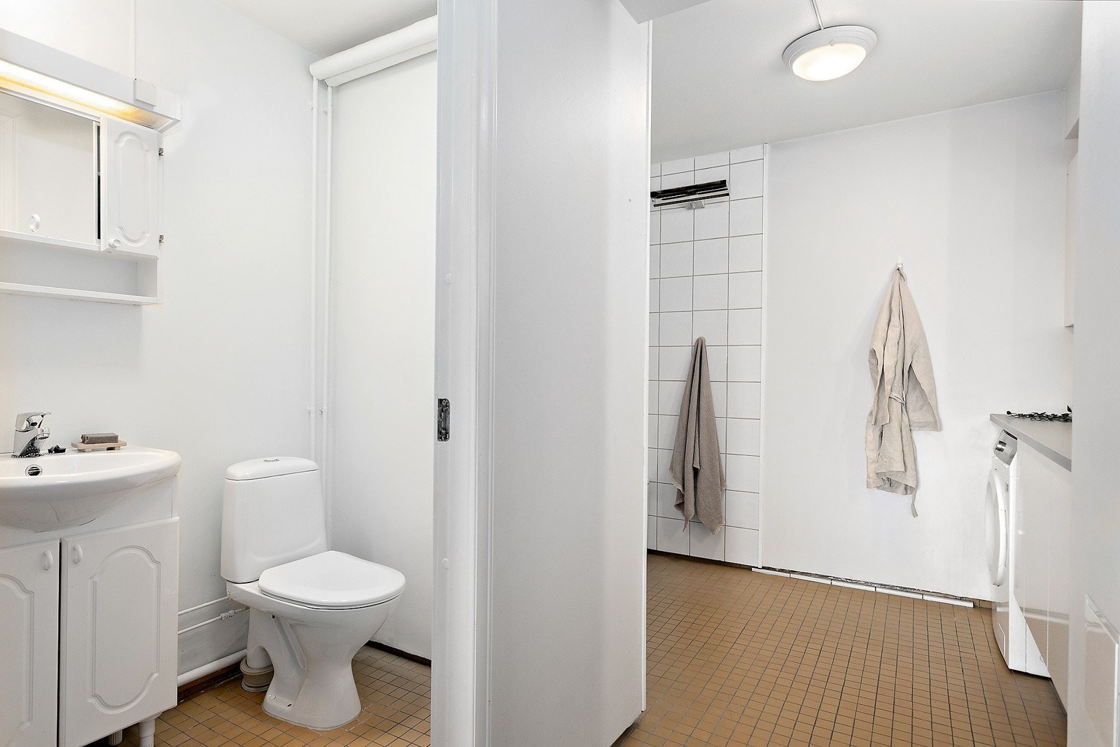 Hele rommet har flislagt gulv og disponerer to servanter, samt mye skapplass Galleribilde
