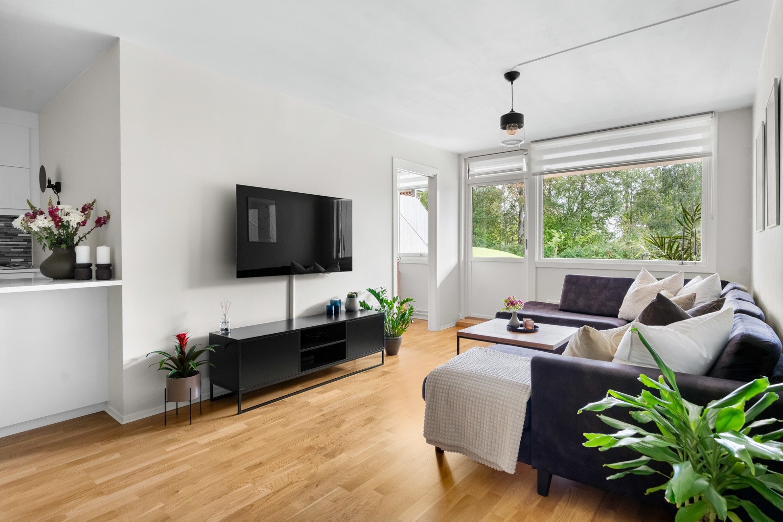 Romslig stue med god plass til sofa med tilhørende møblement, medievegg og spisebord Galleribilde