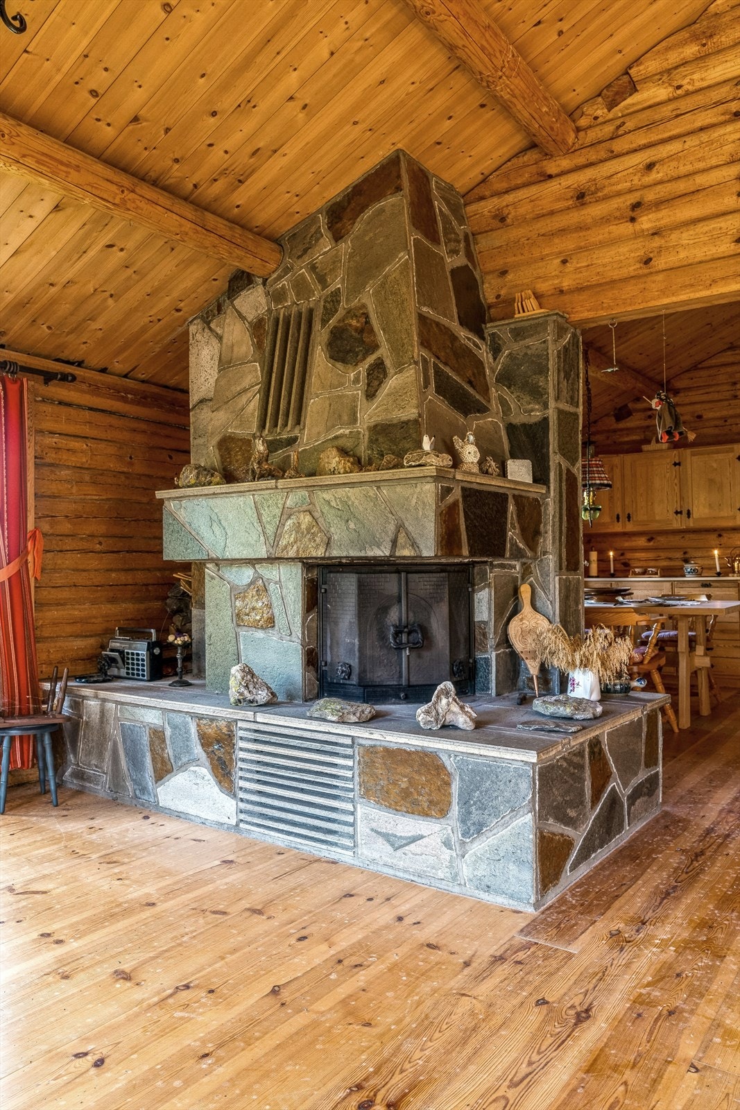 Stuen har en stor skiferkledd peis som gir god varme i hytta. Galleribilde