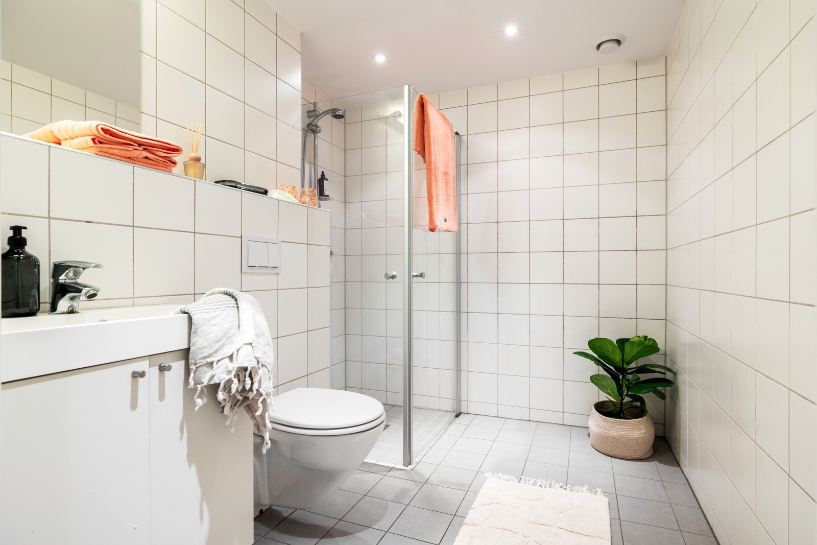 Badet er utstyrt med vegghengt toalett, et romslig dusjhjørne, servantskap med innredning og speil med moderne belysning. Galleribilde