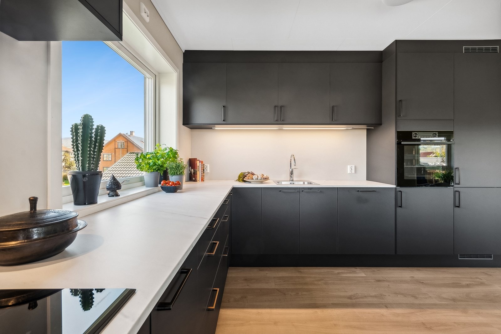 Kjøkkenet har rikelig med oppbevaringsplass, inkludert kolonialskuffer, skap og en praktisk sokkelskuff med integrert krakk. Galleribilde