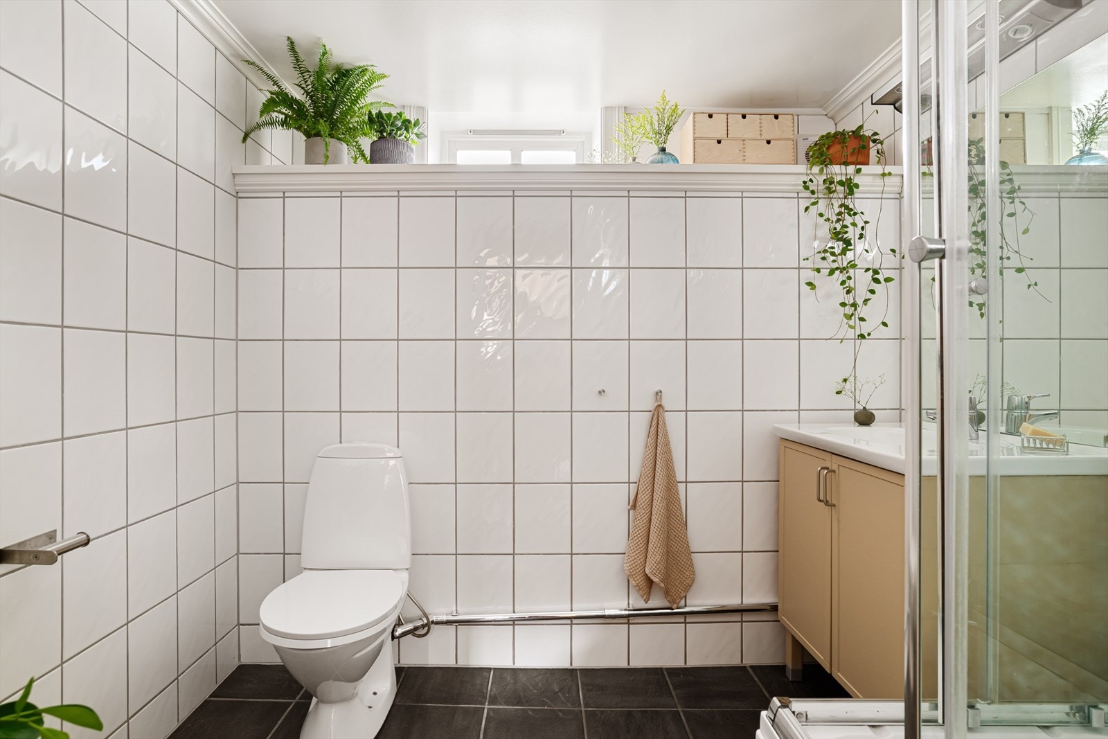Leilighetens baderom er også bygget i 2003/2004, og er flislagt i nøytrale farger. Galleribilde