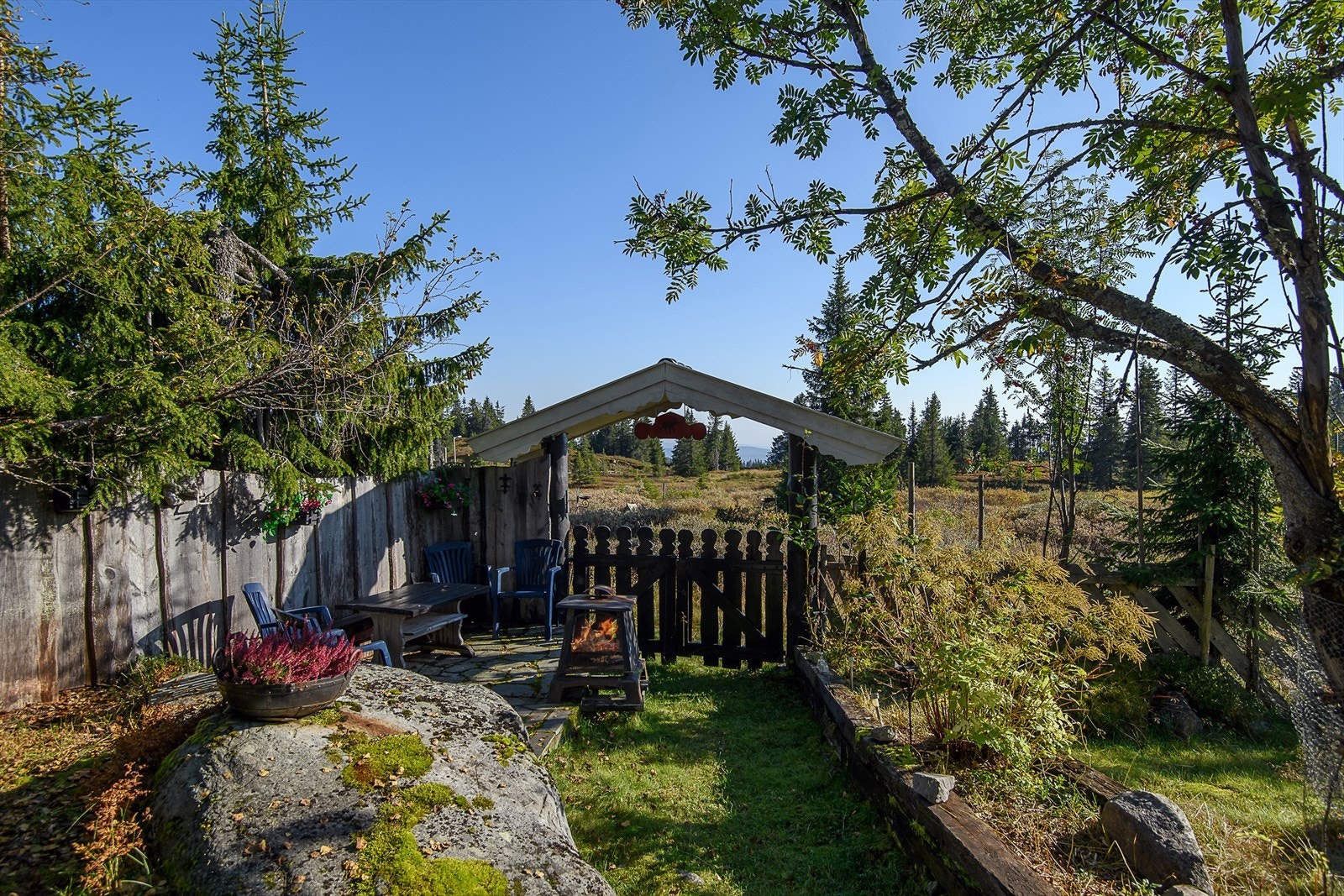 Tomten er utrolig sjarmerende og godt utnyttet med flere soner og sitteplasser. En liten portal gir en snartvei ut i løypa og turterrenget. Galleribilde