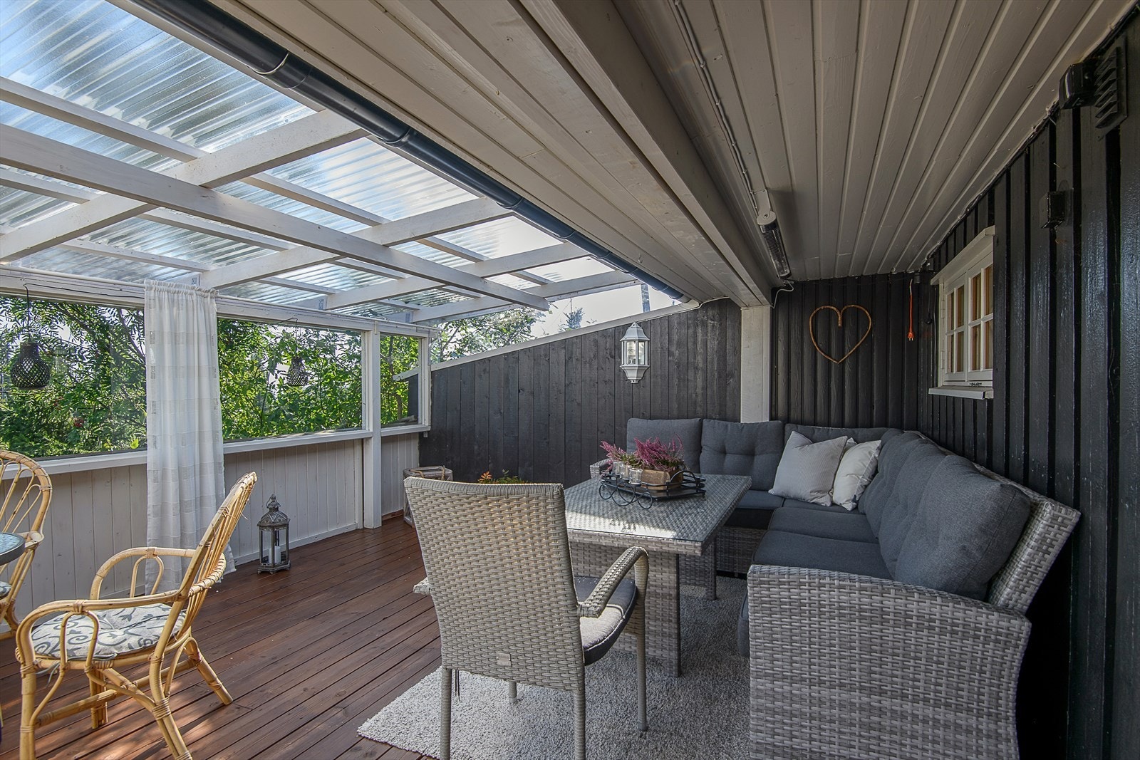 En overbygget og lun del av verandaen blir som en ekstra stue store deler av året. God plass til en sitte gruppe. Galleribilde