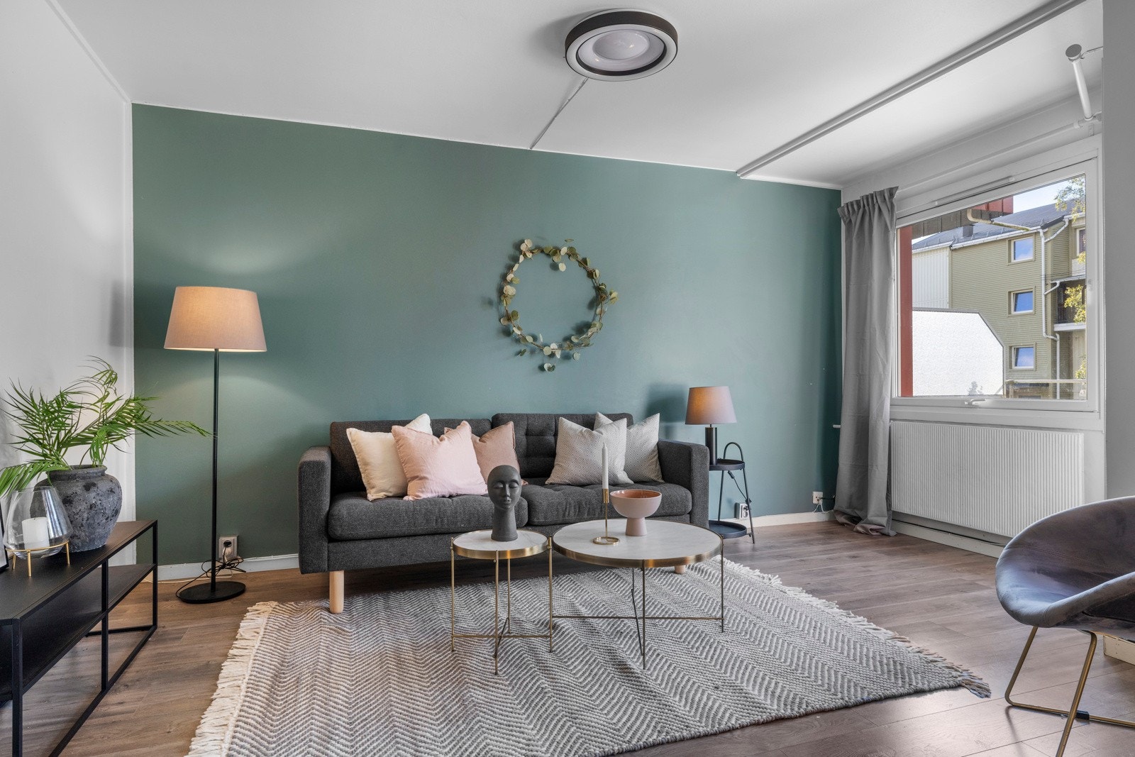 Stuen er et hyggelig oppholdsrom med en grønn kontrastvegg, gode lysforhold og utgang til balkong Galleribilde
