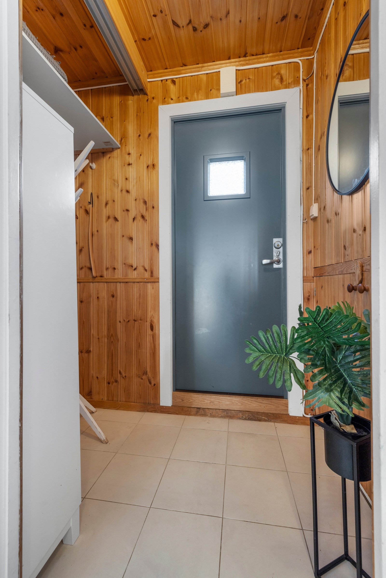 I entreen på innsiden er det gang med lyse fliser på gulvet og naturlige, panelkledde vegger Galleribilde