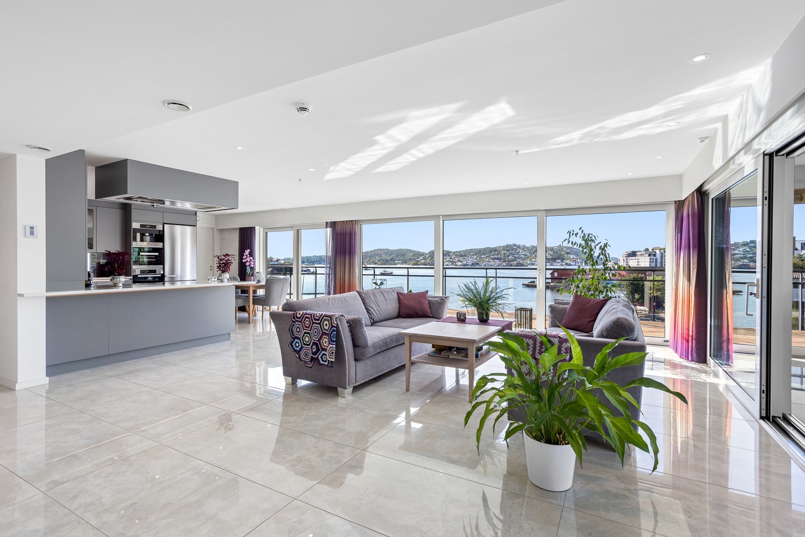 Velkommen inn - En nydelig stue med store og blanke fliser på gulv og store vindusflater hvor den nydelige utsikten kommer frem. Vannbåren varme i gulvet gir en behagelig romtemperatur Galleribilde