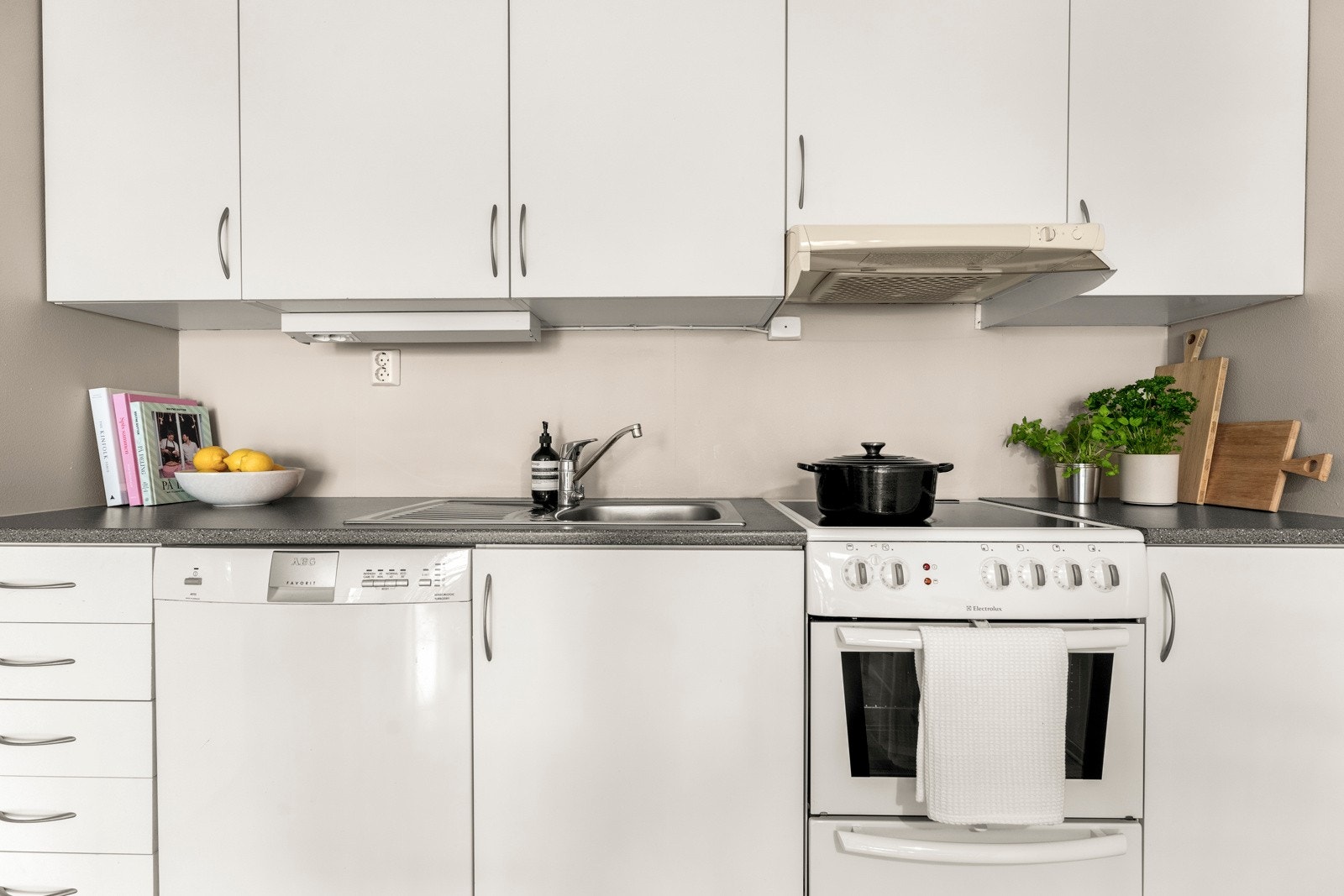 Kjøkkeninnredning med glatte fronter, laminat benkeplate og belysning under overskap. Galleribilde