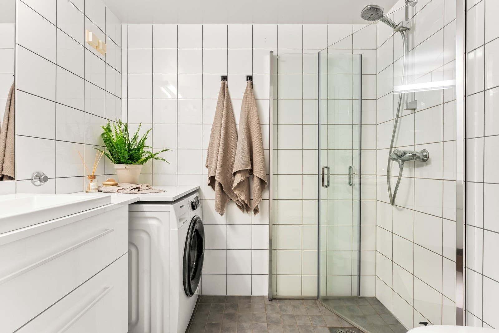 Lyst og fint flislagt bad med et rent uttrykk. Opplegg for vaskemaskin og behagelig gulvvarme. Galleribilde