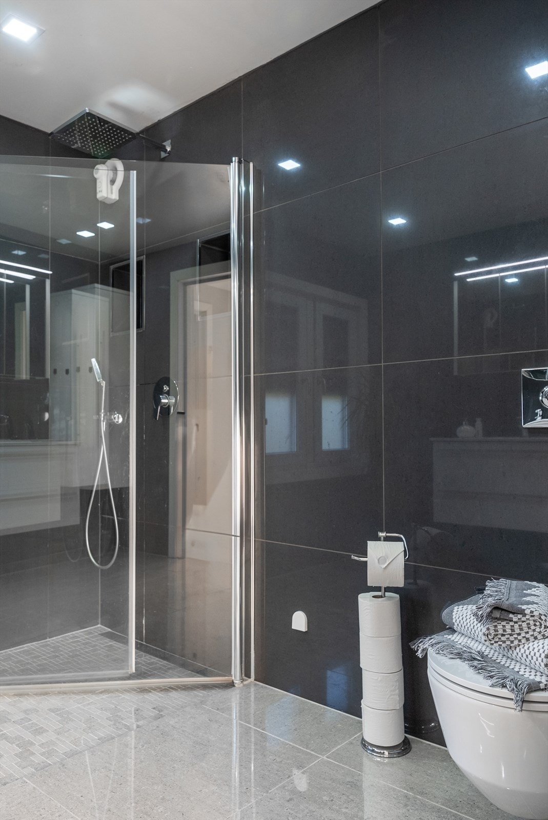 Dusjhjørnet er utstyrt med herdet glassdører og toalettet er veggfestet med innebygget sisterne. Galleribilde