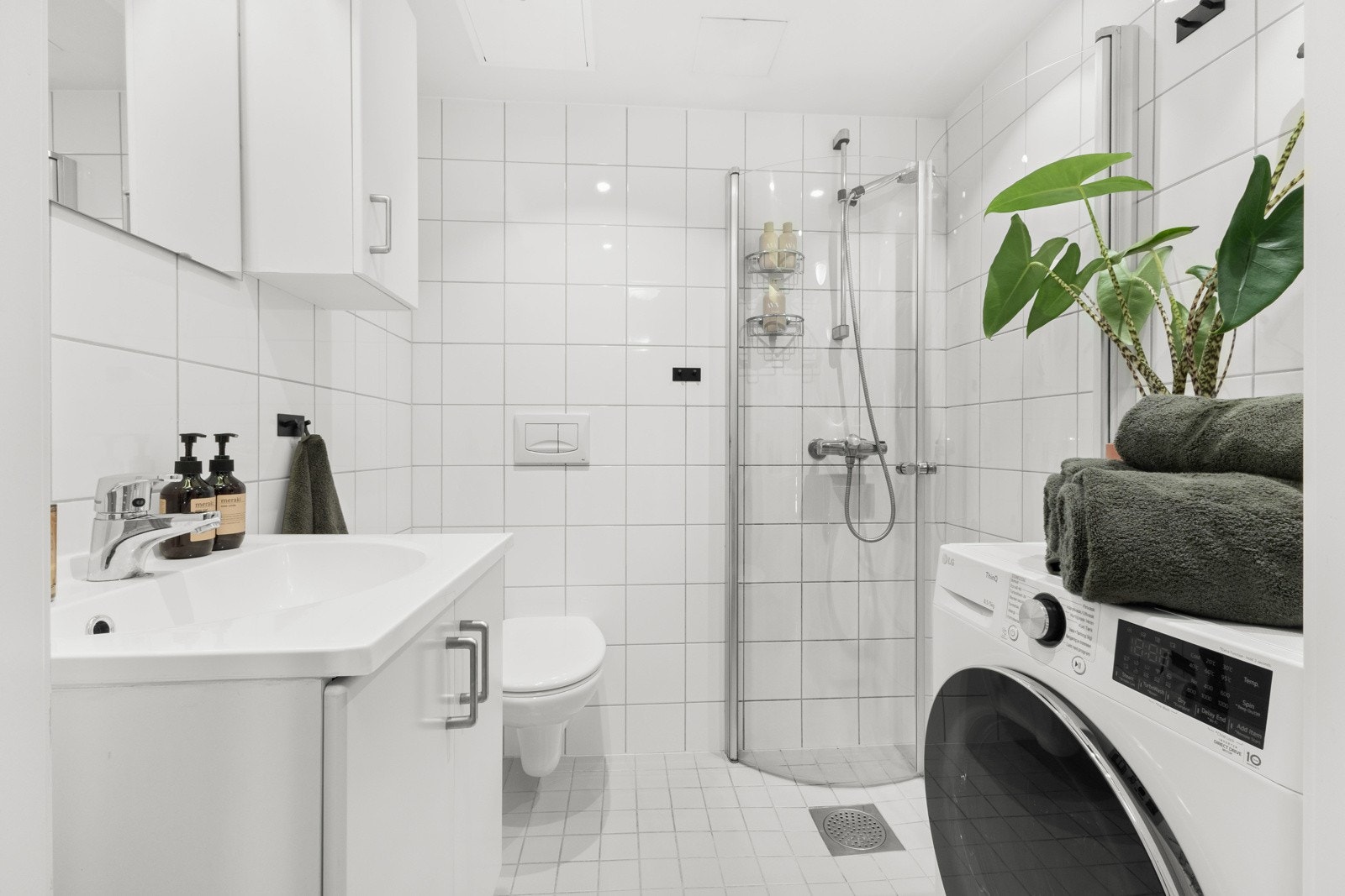 Pent flislagt baderom med downlights i tak og varmekabler i gulv. Opplegg for vaskemaskin Galleribilde