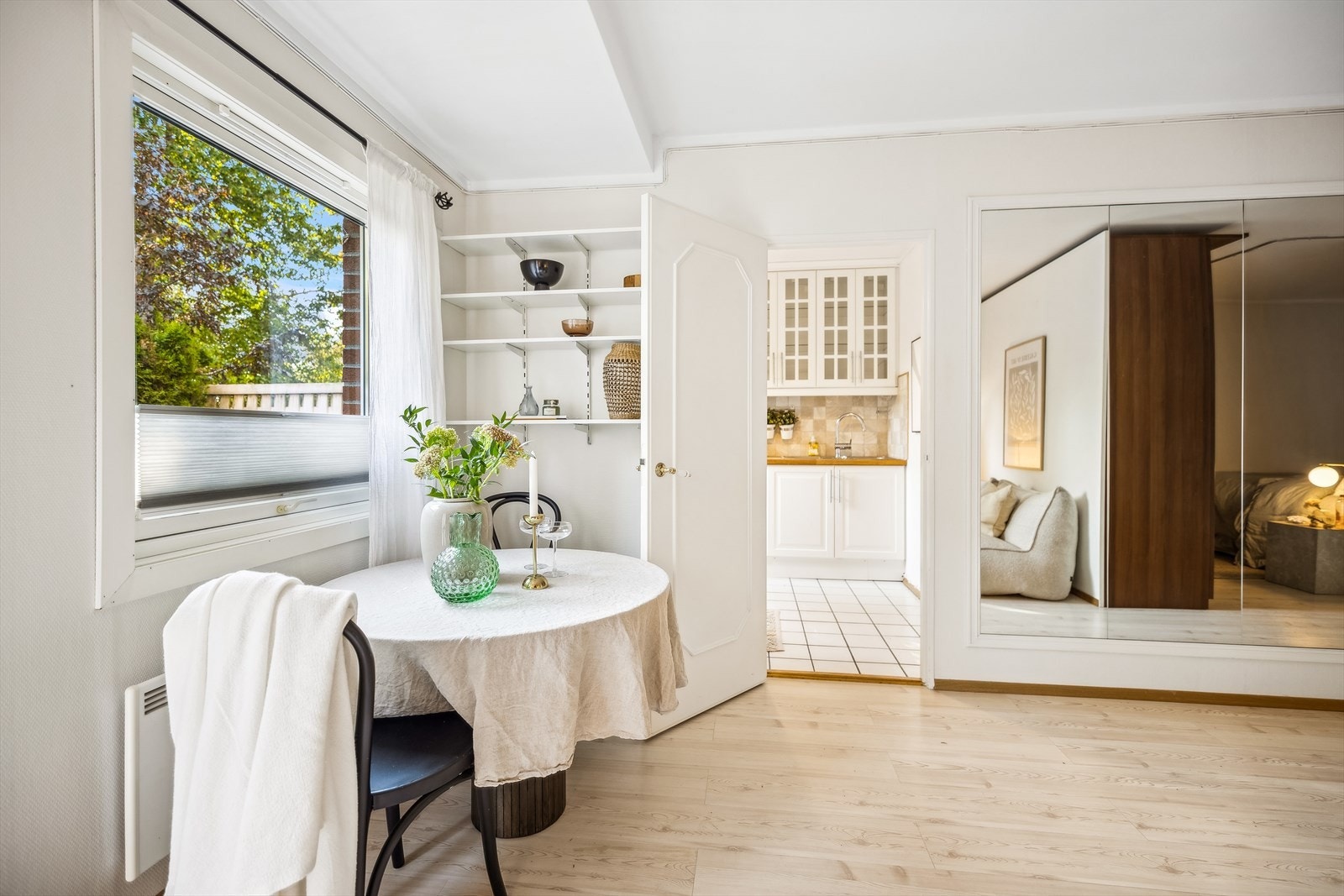 Spisebord i tilknytning til kjøkken. Leiligheten har en flott skjermet, tilbaketrukket beliggenhet. Utsikt fra vindu mot markterrasse og frodig skog. Galleribilde
