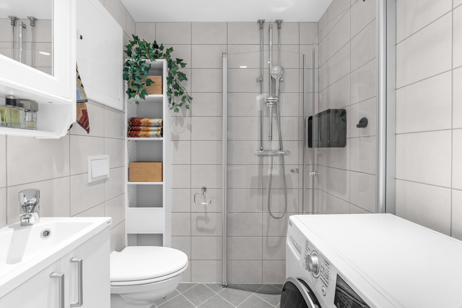 Delikat helfliset bad med downligths i himling og varmekabler i gulv. Det er opplegg for vaskemaskin. Galleribilde