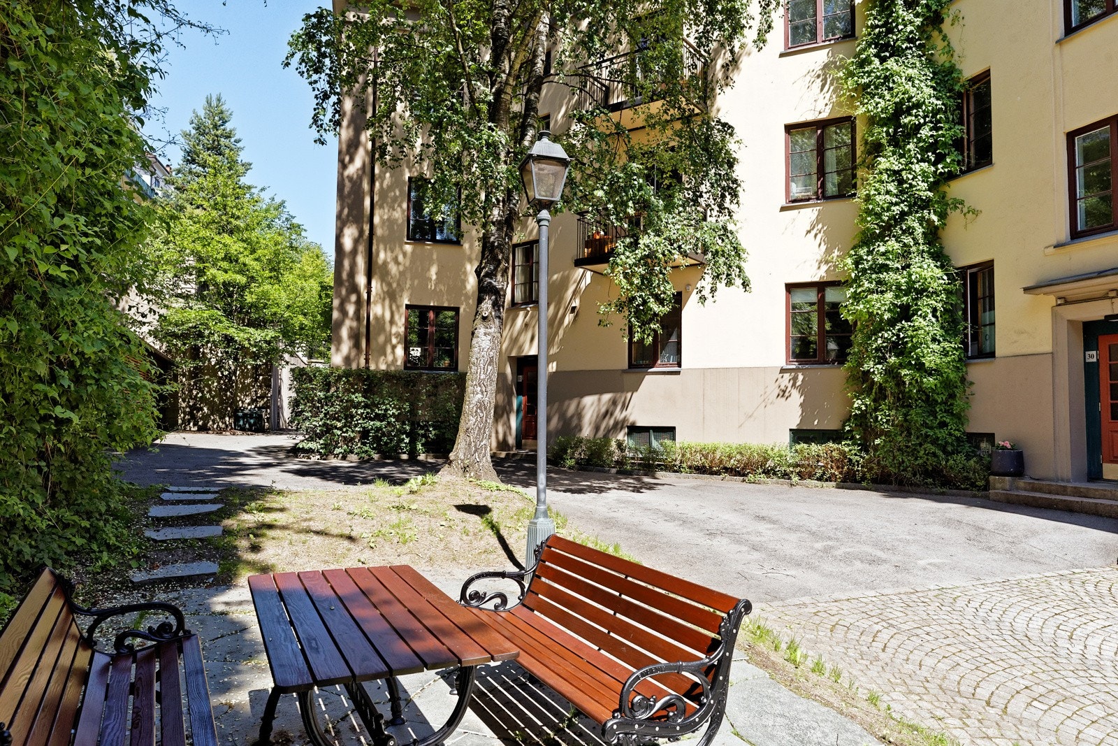 Borettslaget disponerer en frodig og rolig bakgård med hyggelig sittegruppe Galleribilde