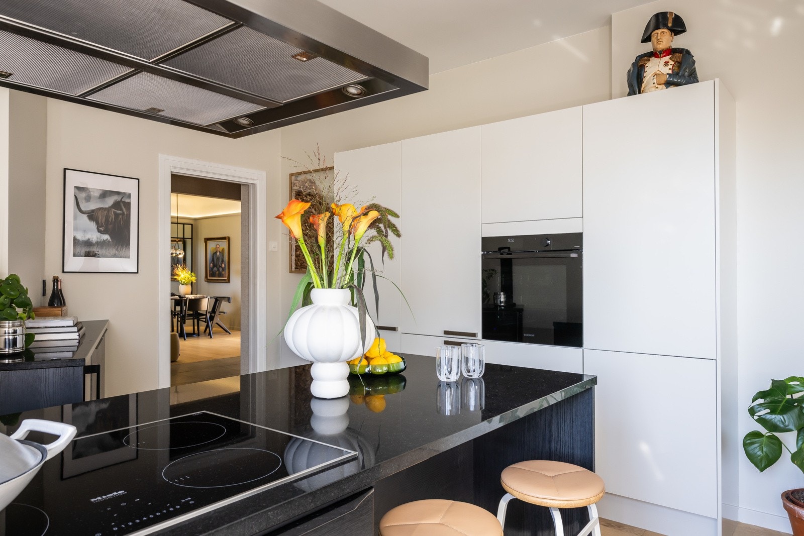 Kombinasjon av sort eik og hvite høyskap. Solid granitt benkeplate. Galleribilde