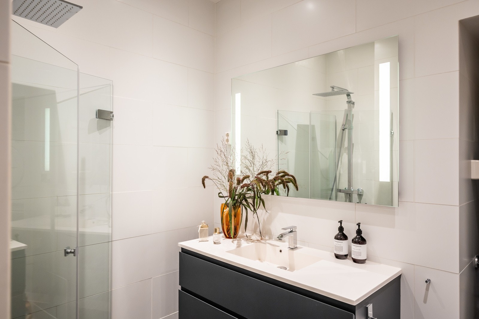 Arealet er godt utnyttet med dusjløsning med innfellbare dusjdører, veggmontert klosett og heldekkende servantplate. Galleribilde