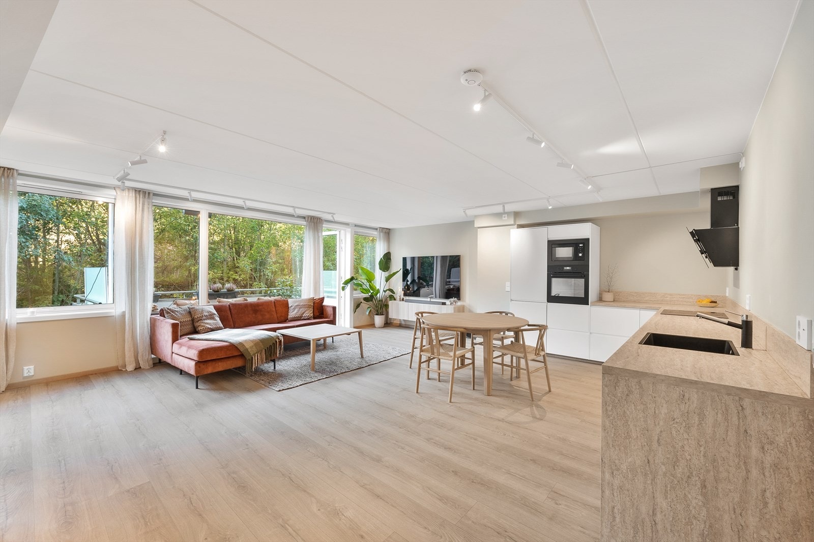 Romslig stue med store vinduer og åpen kjøkkenløsning. Galleribilde