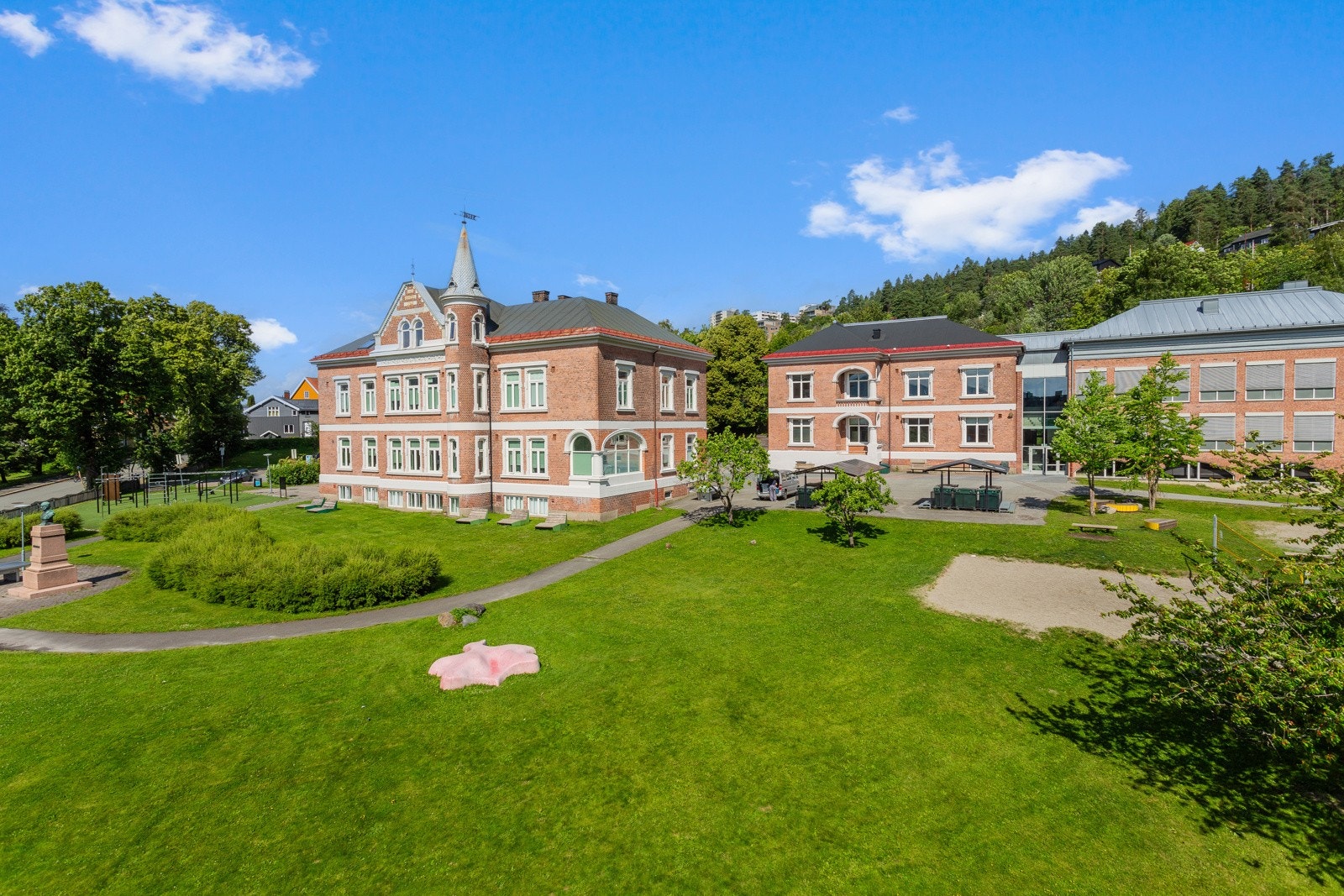 Utsikt over parkmessige grøntarealer og den erværdige bygningsmassen til Børresen skole. Galleribilde