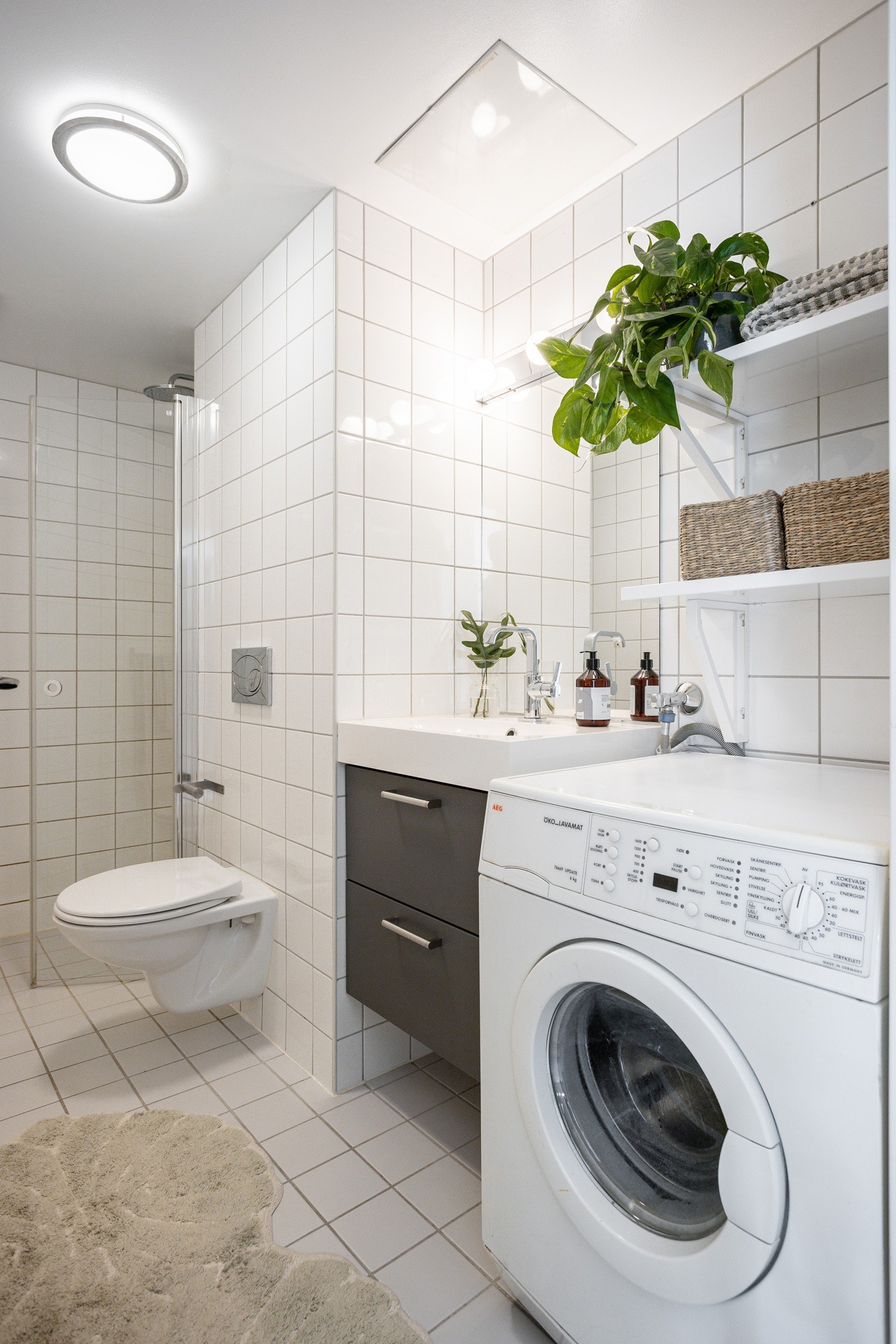 Badet har moderne innredning, varmekabler på gulvet og opplegg for vaskemaskin. Galleribilde