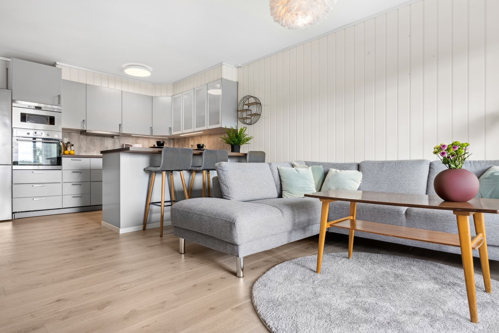 Stue/kjøkken med lyse vegger og slitesterkt laminat gulv Galleribilde