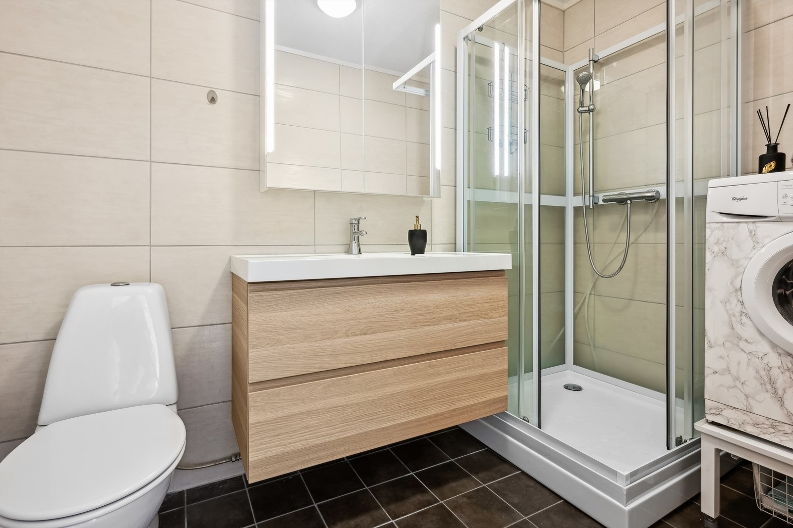 Badet ble pusset opp i 2014 av forrige eier. Gulvet er flislagt med elektriske varmekabler. Badet har innredning med nedfelt servant, toalett, dusjkabinett og opplegg for vaskemaskin Galleribilde