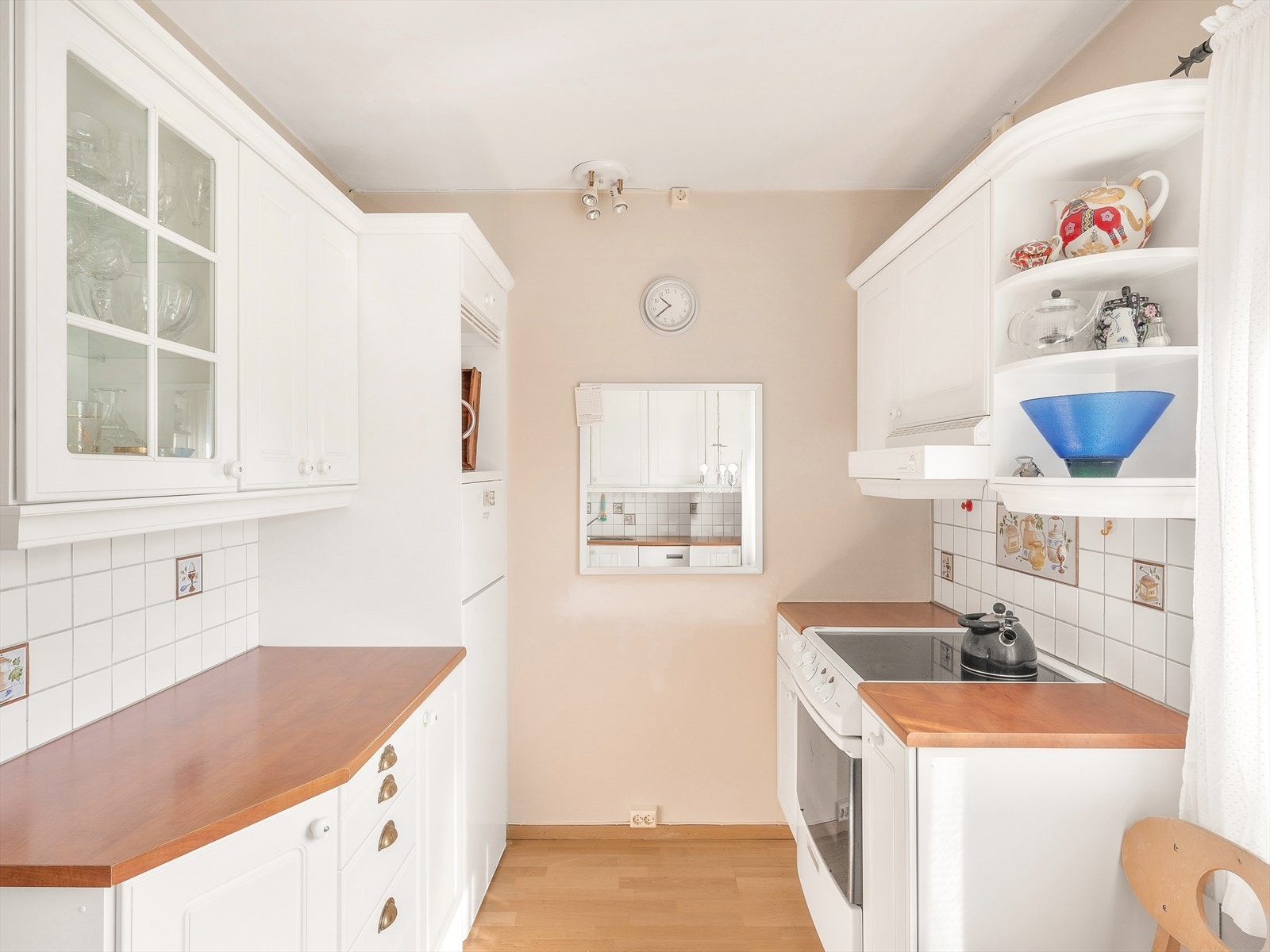 Funksjonelt kjøkken med hvite skap og benkeplater Galleribilde