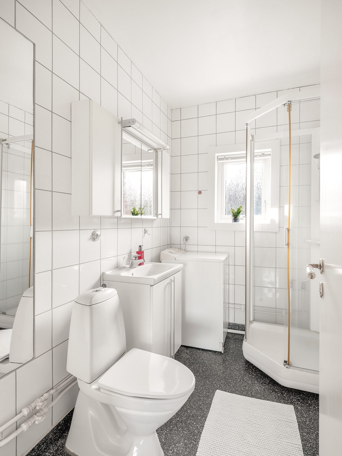 Flislagt bad med dusjkabinett og vaskemaskin Galleribilde