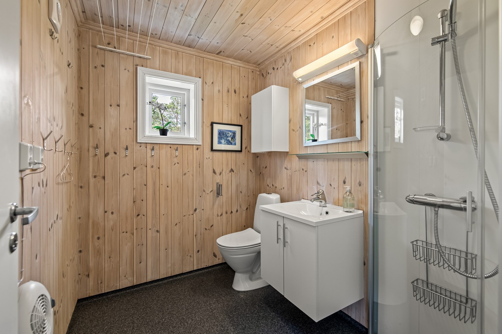 Ett bad er innredet med servant i innredning, toalett og dusjkabinett Galleribilde