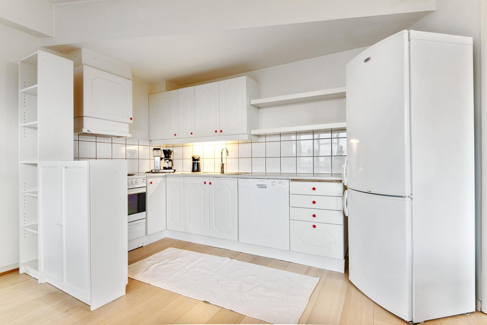 Åpen kjøkkenløsning med komfyr, oppvaskmaskin og kombiskap. Galleribilde