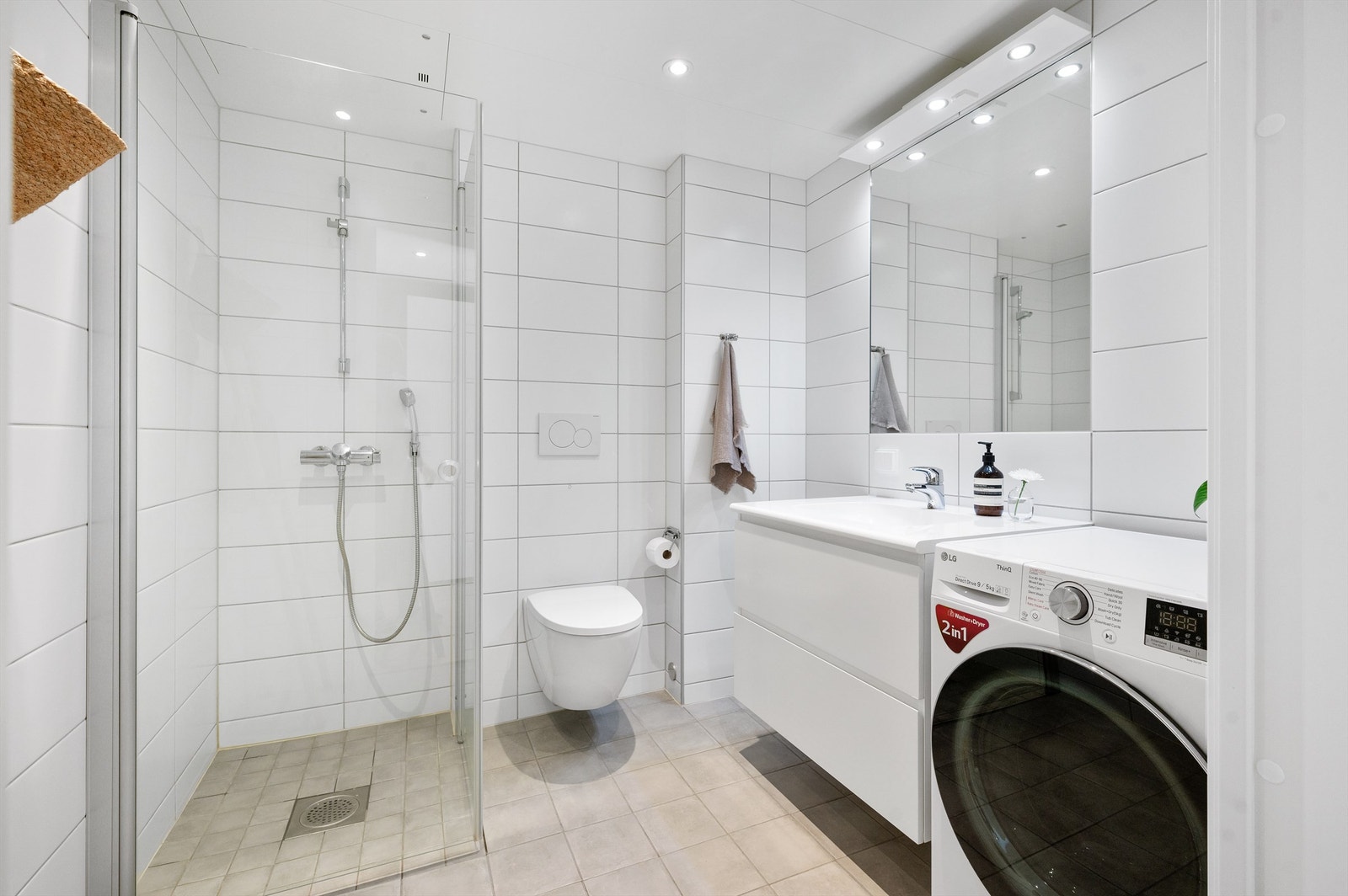 Badet er utstyrt med vegghengt toalett og dusjhjørne med innfellbare glassdører i herdet glass Galleribilde