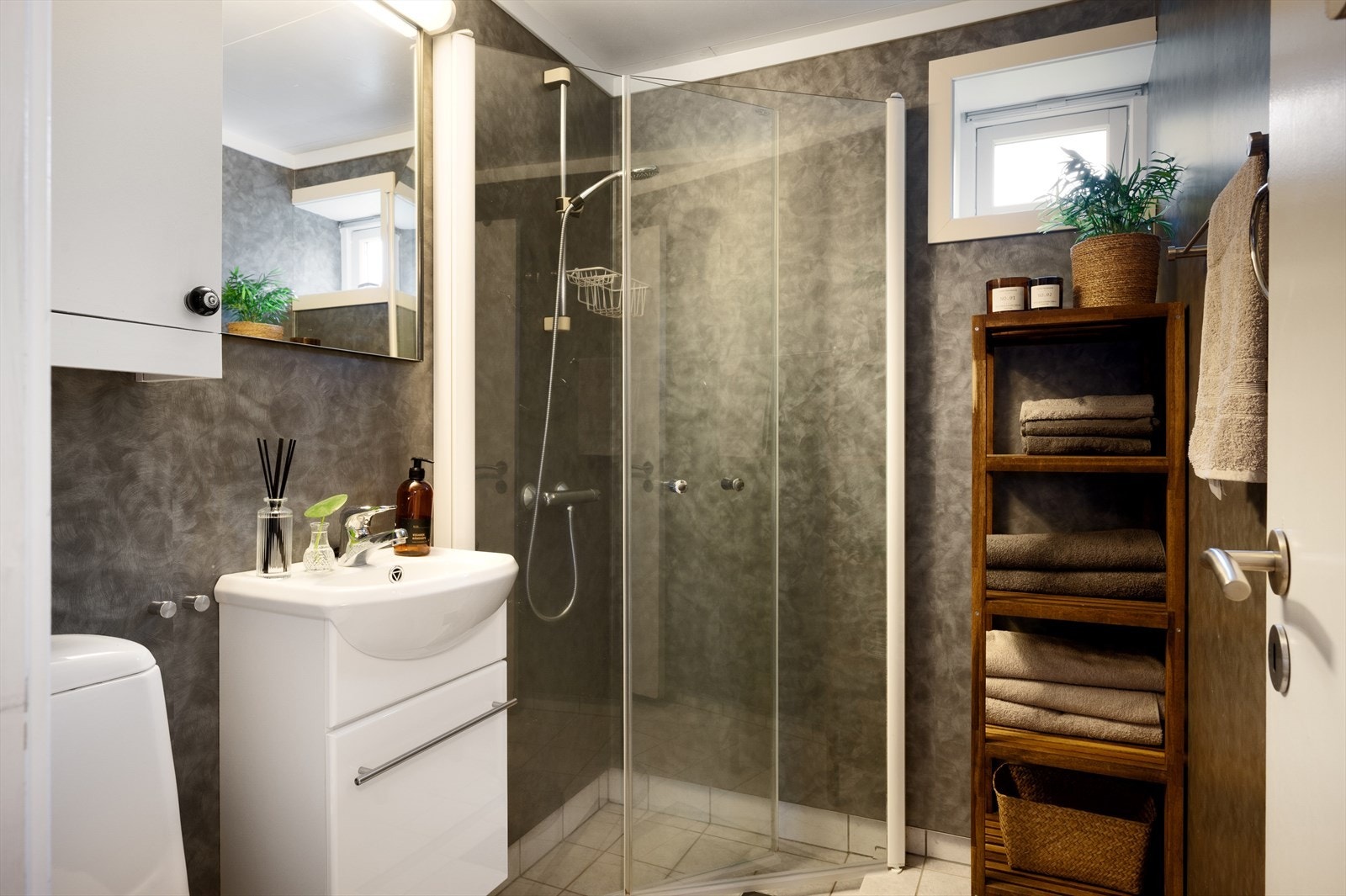 Badet i underetasjen har baderomsplater på vegger og fliser på gulv. Galleribilde