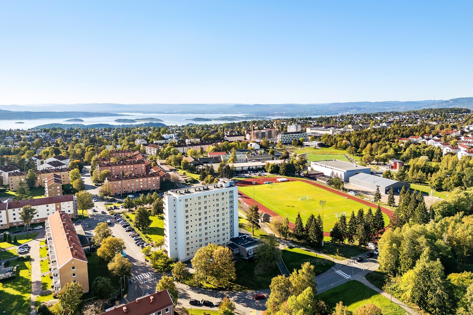 Blokken ligger med mye grøntområder og indrettsarena rett ved Galleribilde