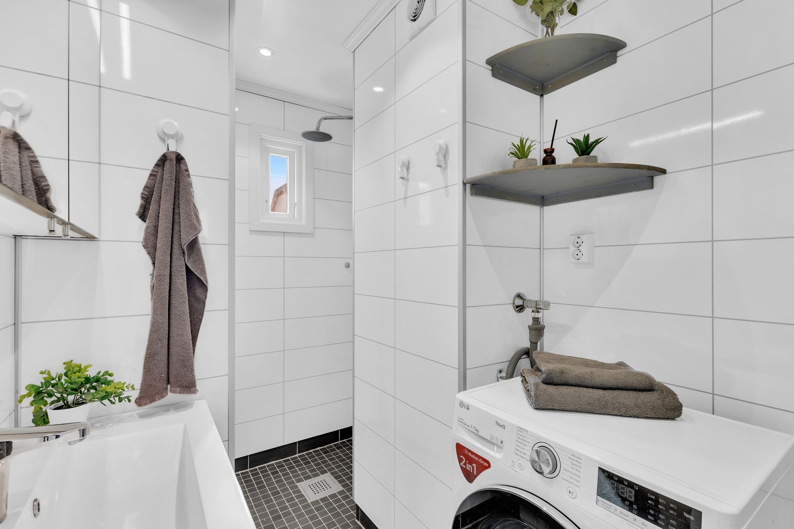Badet er innredet med servant med underskap, dusjnisje, opplegg for vaskemaskin og toalett. Galleribilde