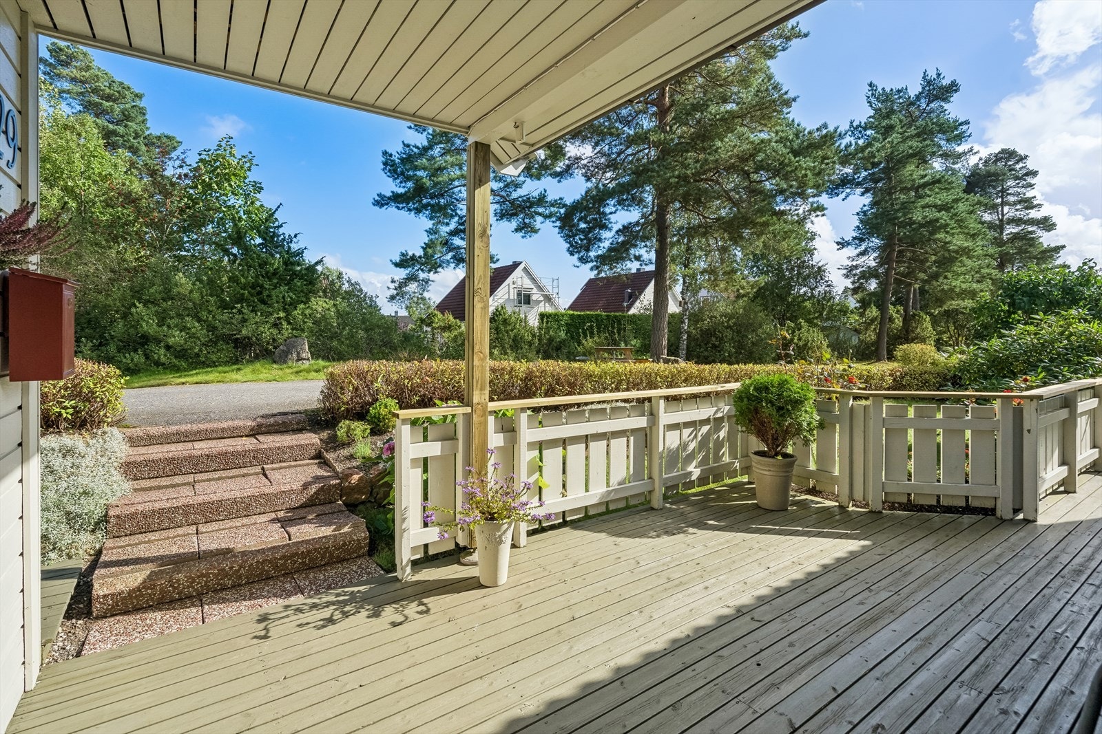 Boligens inngangsparti bidrar til et godt førsteinntrykk med en stor terrasseplatting med morgensol Galleribilde