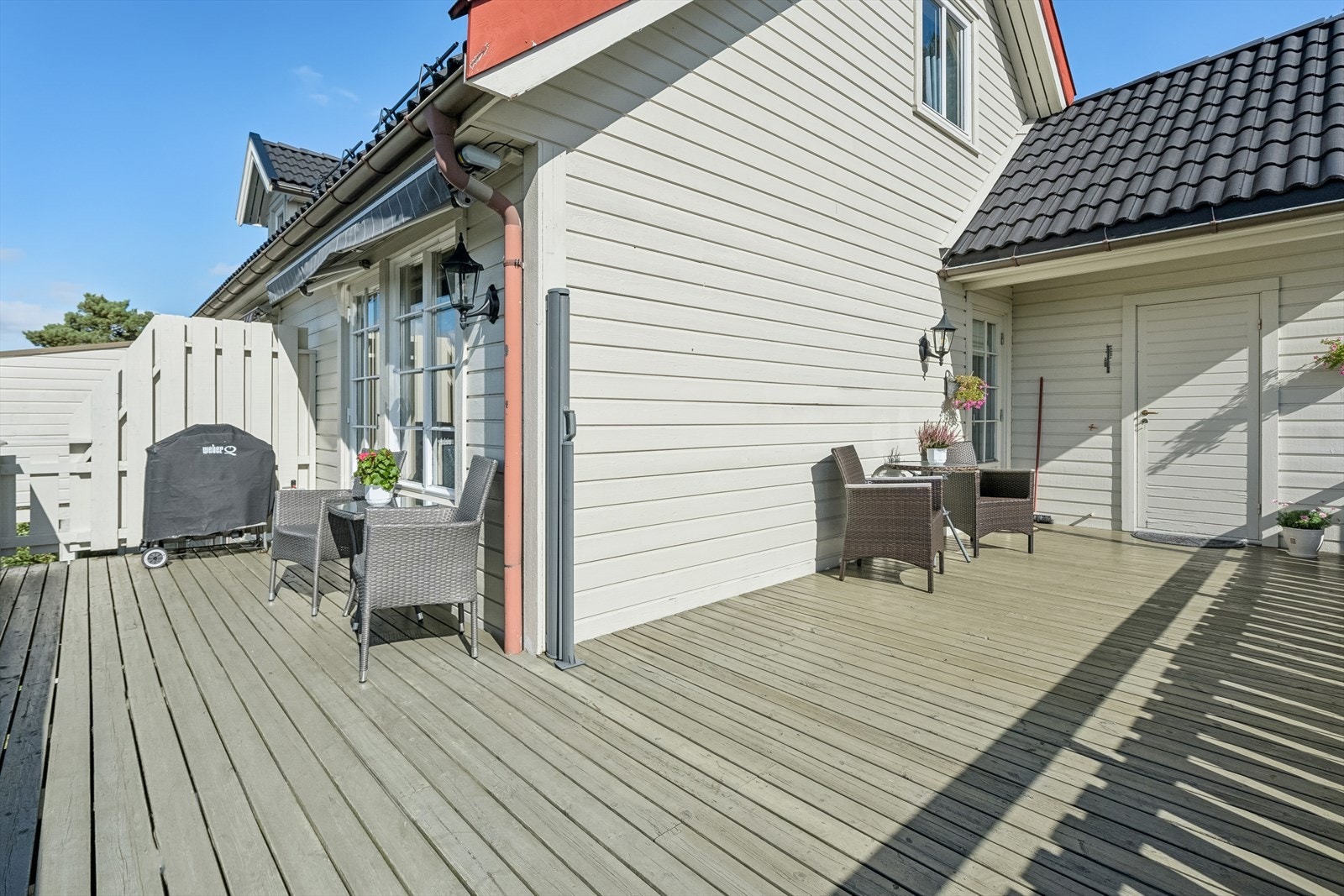 Fra stuen er det utgang til den meget solrike og flotte terrassen som går fra stue til kjøkken. Tilkomst til bod som er gjennomgående til plenareal ved inngangen Galleribilde