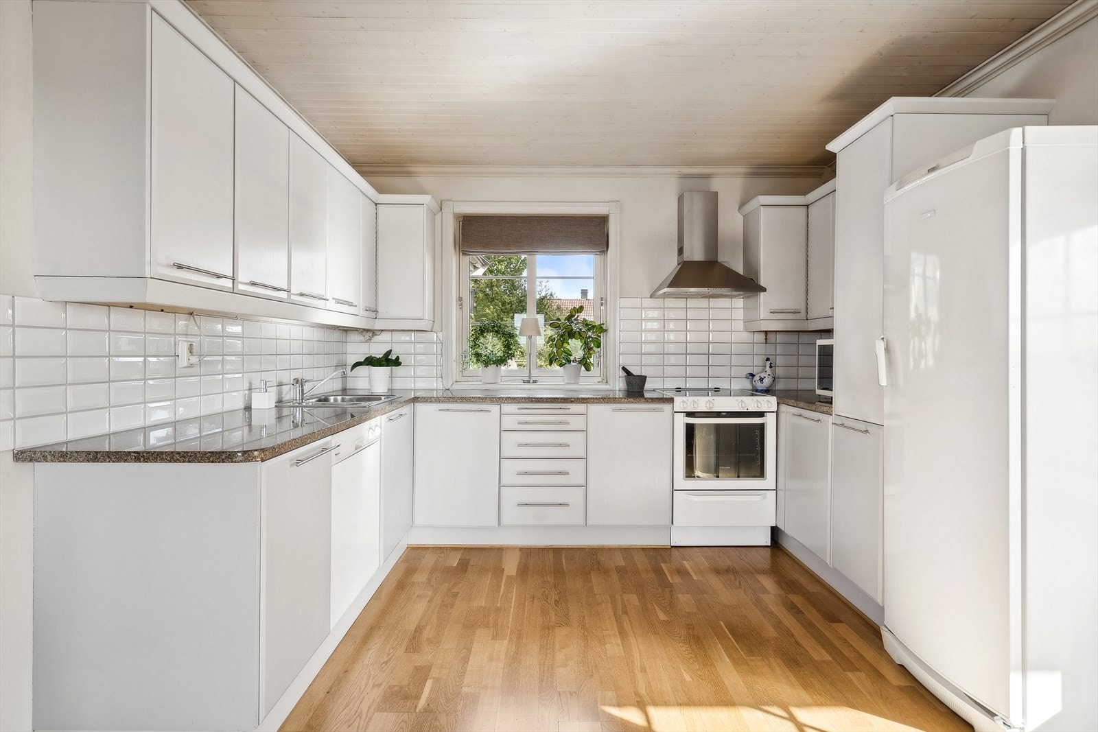 Stort, lyst og tidløst kjøkken med godt med benkeplass fra både over - og underskap Galleribilde