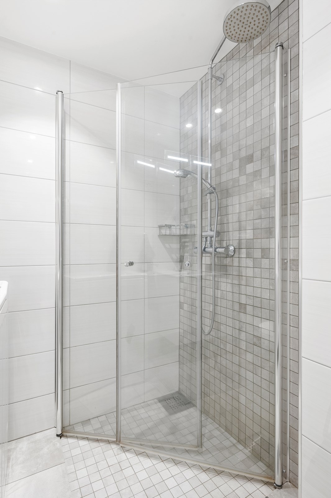 Videre har badet vegghengt klosett og dusjhjørne med svingbare glassdører. Galleribilde