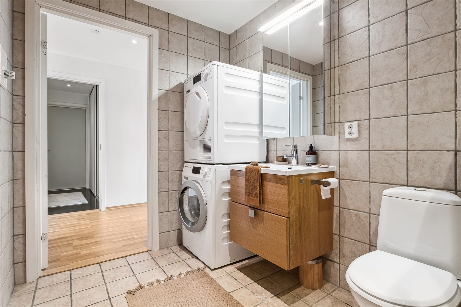 Bad med dusjdører, servant, møbler, wc og opplegg for vaskemaskin. Rør i rør system. Galleribilde