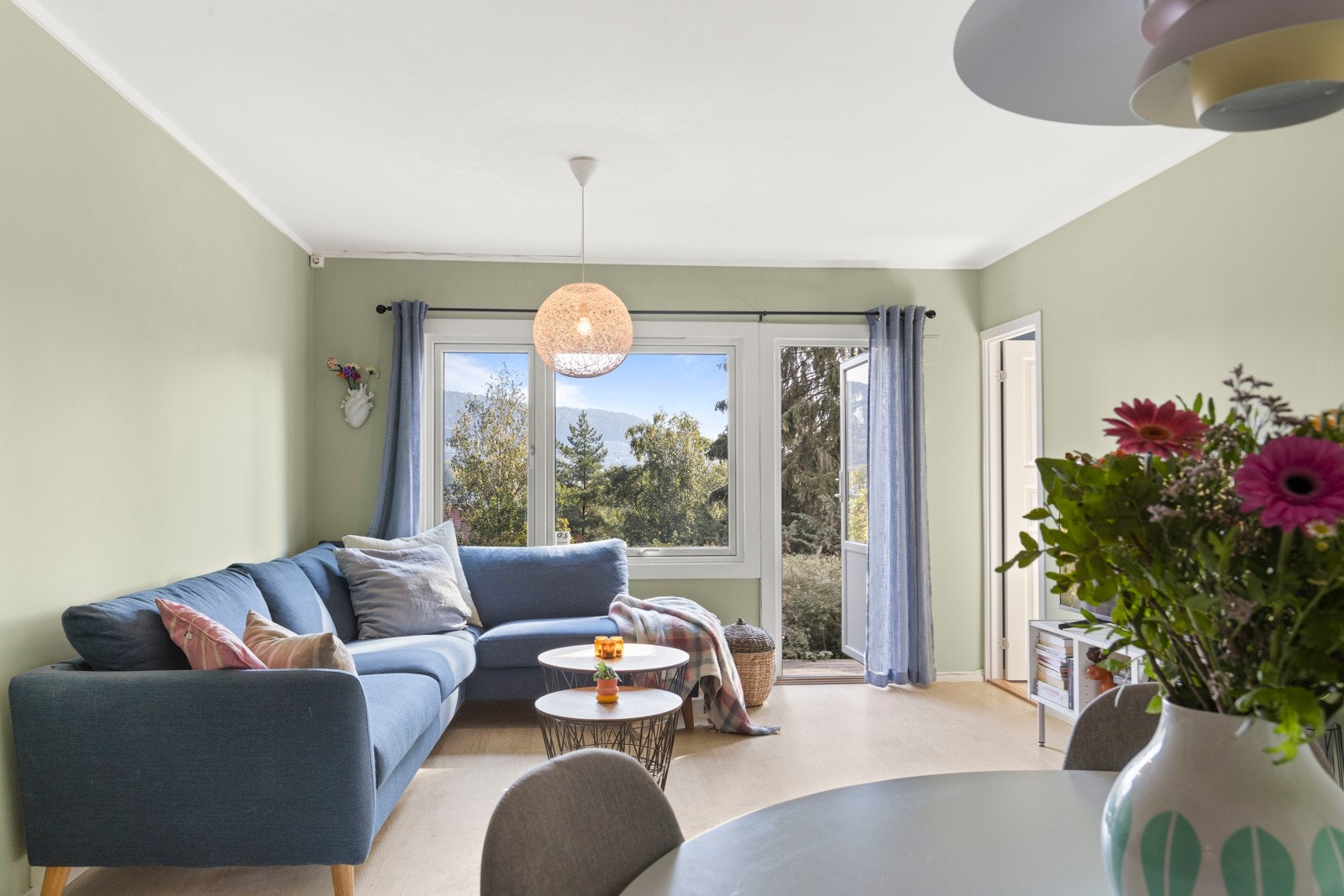 Lys og romslig stue med naturlig tildelte soner for spiseplass og sofaseksjon. Galleribilde