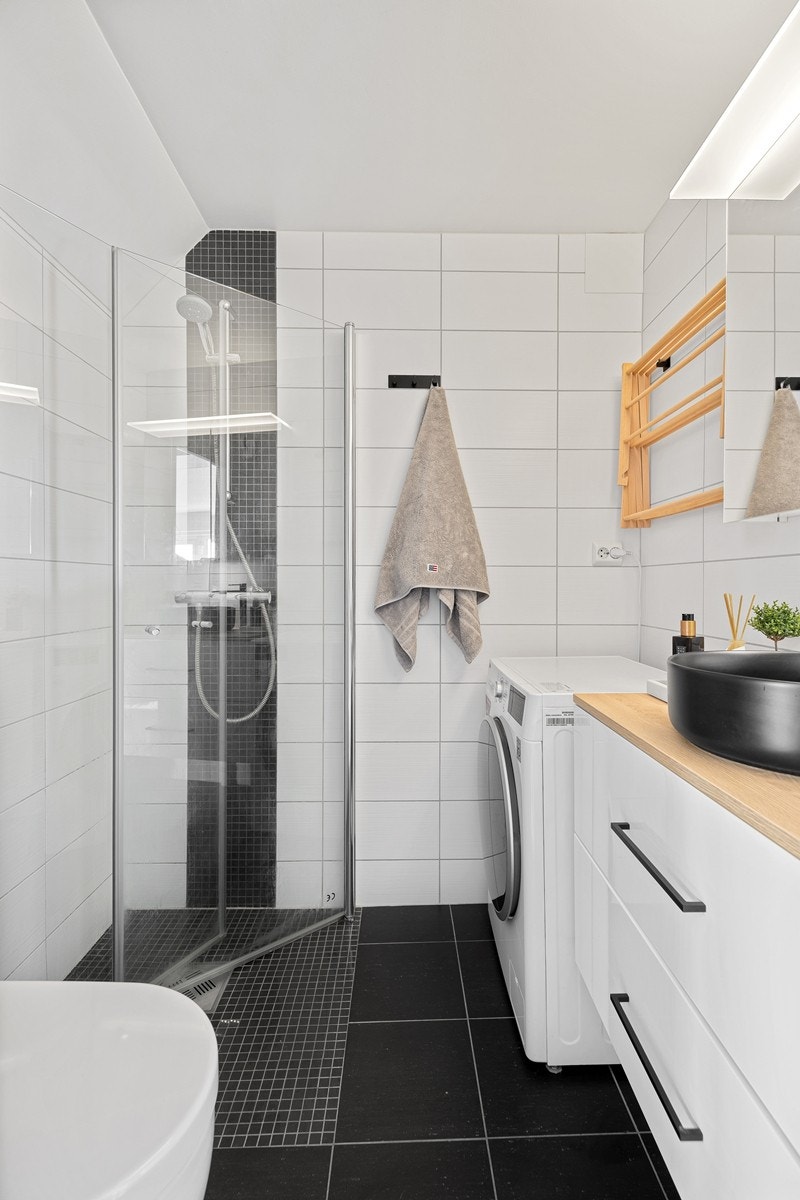 Badet er flislagt og har gulvvarme. Det er dusjnisje med mosaikkfliser som skaper en fin kontrast. Galleribilde